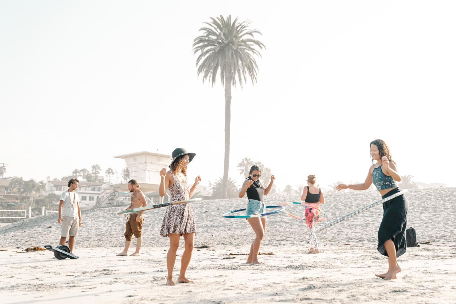 People hooping together next to a palm tree