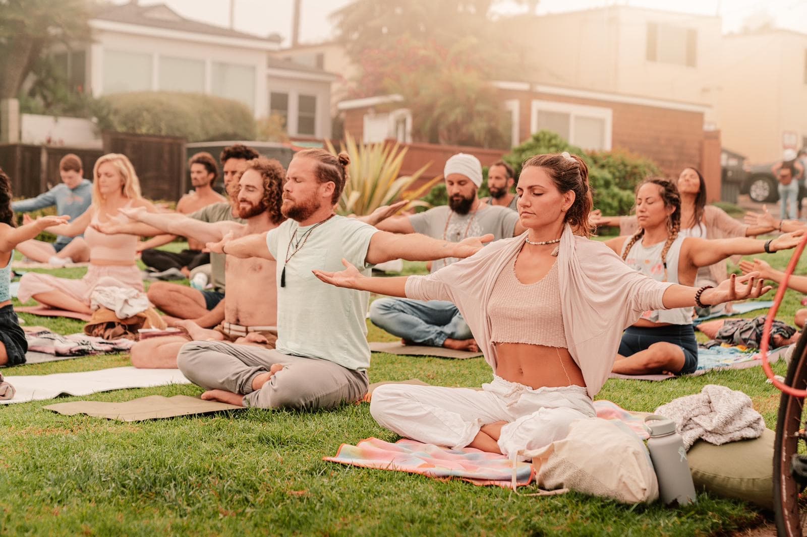 People in a quiet moment of breathwork together outdoors at golden hour