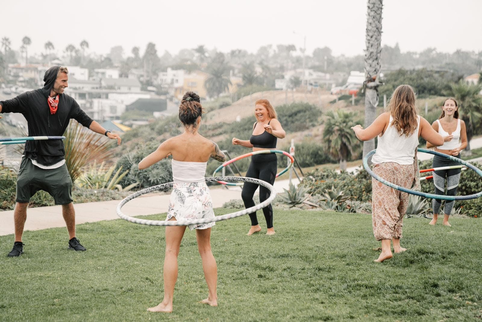 A group playing with hula hoops together on a sunny lawn