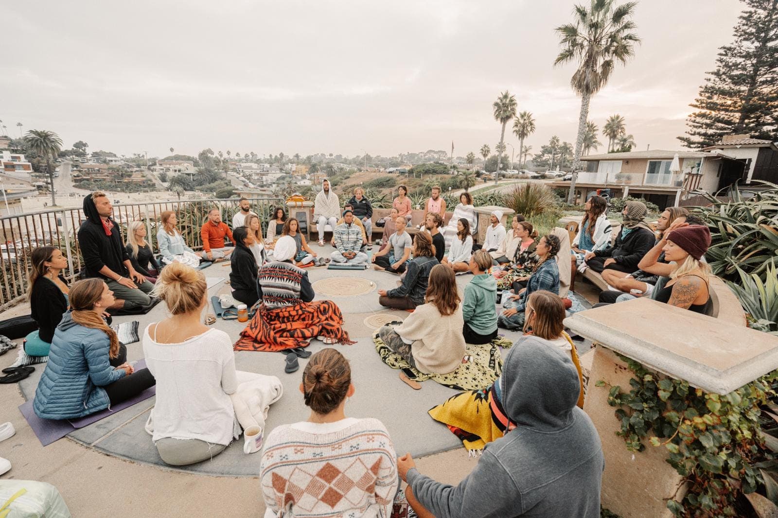 People sitting together on the grass with their eyes closed